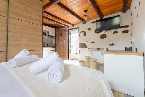 a room with a white bed with towels on it at Quinta entre palmeras in Santa Brígida