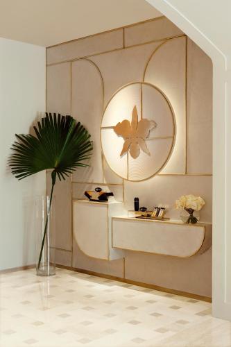 a room with a mirror and a vase with a plant at One&Only Le Saint Géran, Mauritius in Belle Mare