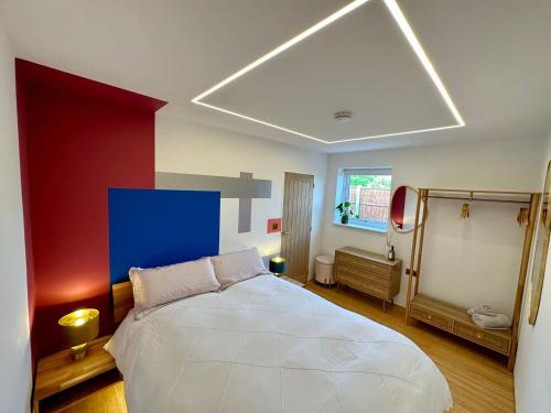 a bedroom with a white bed with a blue wall at Luxurious guest house in Yorkshire with parking in Hemingbrough