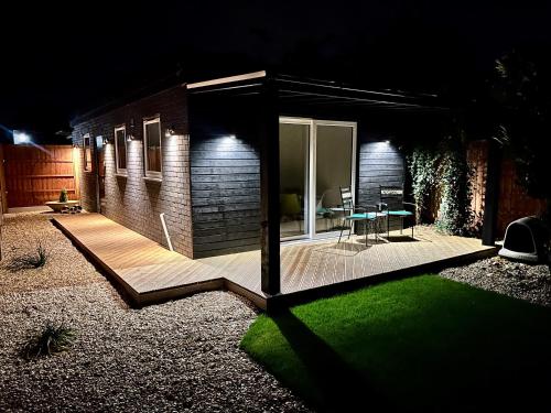 a small house with a patio at night at Luxurious guest house in Yorkshire with parking in Hemingbrough