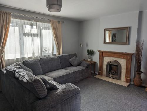 a living room with a couch and a fireplace at Beautiful 2 Bedroom house in Broughton Astley in Broughton Astley