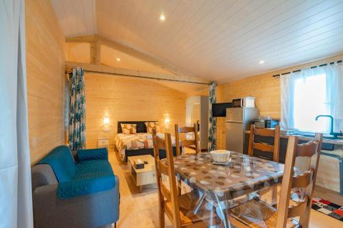 une chambre avec une table à manger et une chambre dans l'établissement Chalet au calme, à La-Gripperie-Saint-Symphorien