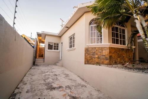 a white house with a palm tree in front of it at Ideal house for families, large groups & cozy in Santa Rosa de Copán