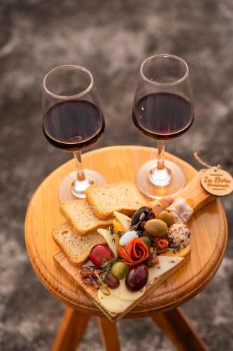 two glasses of wine and a plate of food on a table at Ideal house for families, large groups & cozy in Santa Rosa de Copán