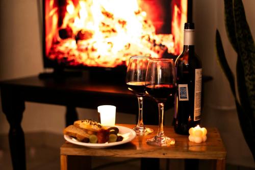 a table with two glasses of wine and a plate of food at Ideal house for families, large groups & cozy in Santa Rosa de Copán
