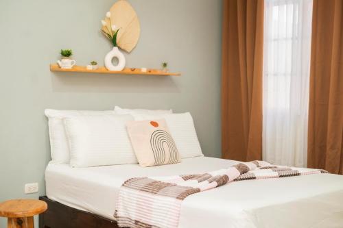 a bed with white sheets and a blanket at Ideal house for families, large groups & cozy in Santa Rosa de Copán