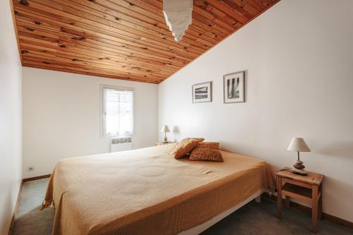 une chambre avec un grand lit avec un plafond en bois dans l'établissement Maison a 4 min du marché et plages, à Saint-Trojan-les-Bains