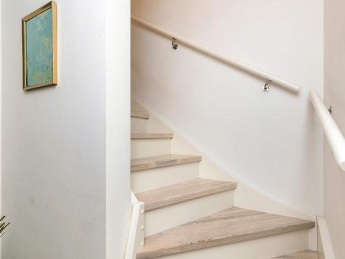 a staircase in a home with white walls and wood floors at 4 star holiday home in Vedbæk in Vedbæk