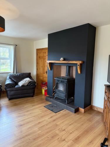 a living room with a fireplace and a couch at #1 - Family or Triple Room in Ballinamore, Leitrim in Ballinamore