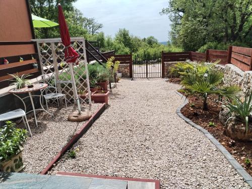 a garden with a gravel pathway with plants at The Forest House Krk 1 in Kras