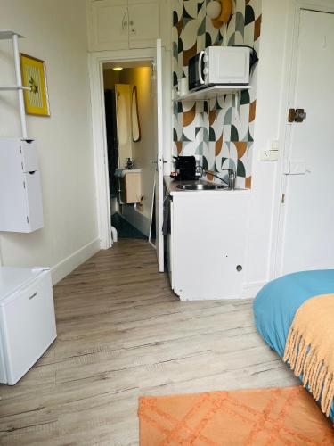 a room with a kitchen with a counter and a refrigerator at Place équipe au Coeur de Paris avec Vue sur l'Arc de Triomphe et la Tour Eiffel in Paris