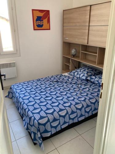 une chambre avec un lit avec une couette bleue dans l'établissement Evasion Marine, à Palavas-les-Flots