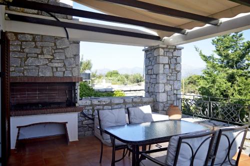 a patio with a table and a fireplace at Malvazios Villas #7 in Gythio