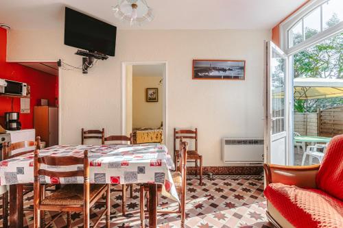 une salle à manger avec une table et une télévision dans l'établissement Maison tranquille près forêt et mer, à Saint-Trojan-les-Bains