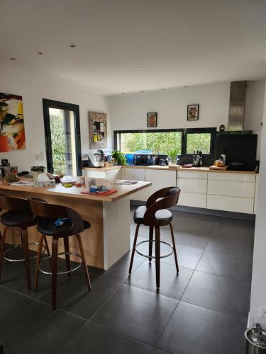 - une cuisine avec un comptoir et des tabourets dans l'établissement Annie-laure, à La Celle-sous-Gouzon