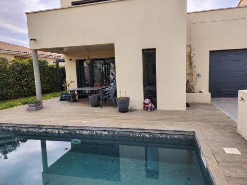 un chien assis sur une terrasse à côté d'une maison dans l'établissement Annie-laure, à La Celle-sous-Gouzon