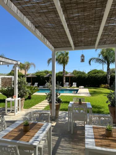 un patio avec tables et chaises et une piscine dans l'établissement Sun of Sicily, à Noto