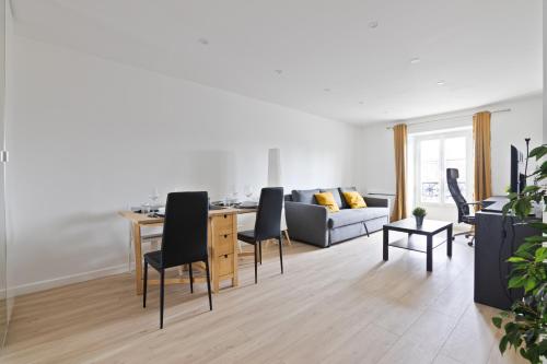 un salon avec un canapé, une table et des chaises dans l'établissement 1 Bedroom Apartment Quartier Austerlitz Free Netflix, à Paris