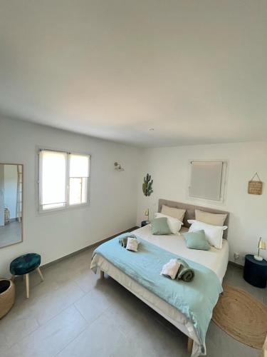une chambre blanche avec un grand lit dedans dans l'établissement Mini villa,, 700 m de la plage à pieds, à Pinarellu