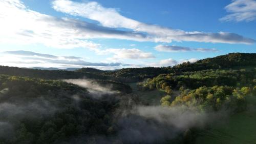 an aerial view of a valley with trees and clouds at Off-Grid Cabin with Fire Pit and Trail Access Nestled in Nature in Sugar Grove, West Virginia in Sugar Grove