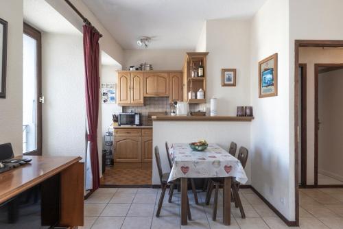 - une cuisine avec une table, une table et des chaises dans l'établissement Pavillon Appartement n°30, à Chamonix-Mont-Blanc