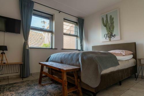 a bedroom with a bed and a table and a window at De Allerhof in Hattem
