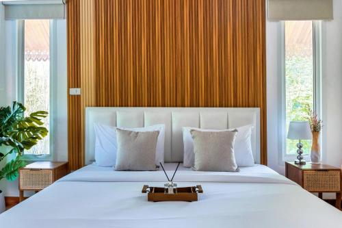 a bedroom with a large white bed with a gold wall at 提供免费汽车使用的含泳池被墅房间 in Chiang Mai