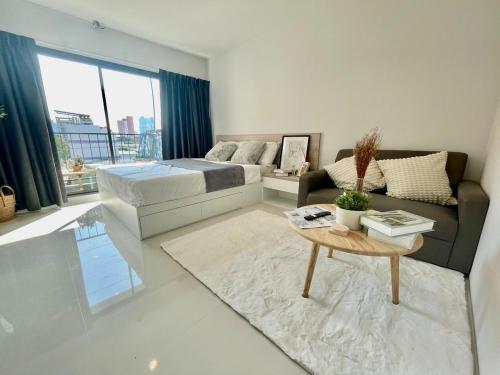 a bedroom with a bed and a couch and a table at Cozy Stay! Near Chatuchak Market 816 in Bangkok