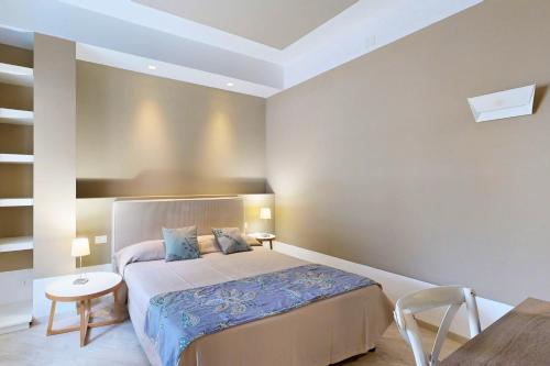 a bedroom with a bed and a table and a chair at Aegusa Hotel in Favignana