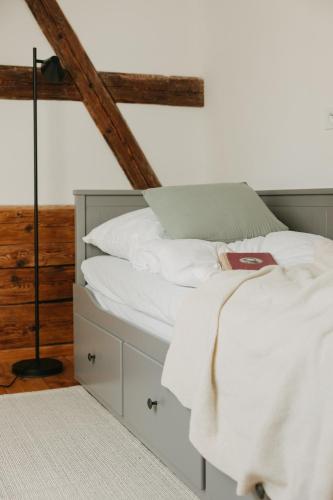 a bed with white sheets and pillows in a room at Palitz No 17 - venkovské stavení in Lipová