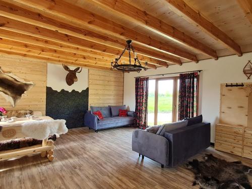 a living room with a couch and a table at Przyjazna zagroda leśne runo in Borek