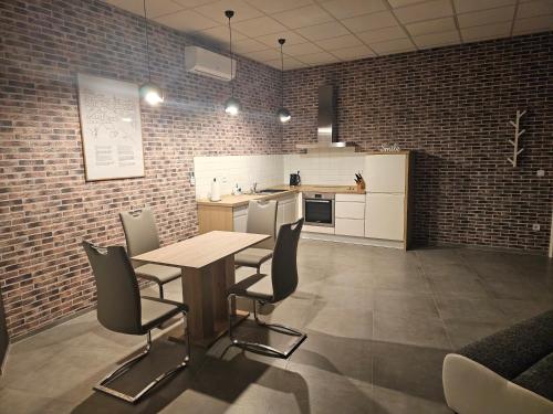 a kitchen with a table and chairs in a room at Apartments NESTL in Ptuj