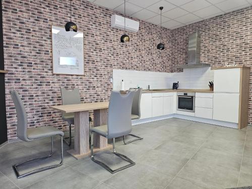 a kitchen with a table and chairs and a brick wall at Apartments NESTL in Ptuj