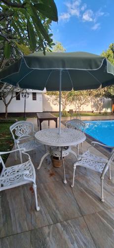 a table and chairs with an umbrella next to a pool at Safari Eye Hotel - Thissa in Debarawewa