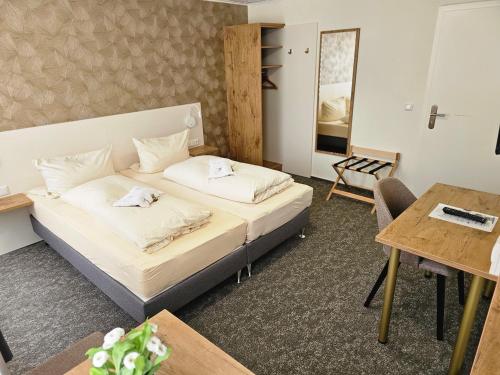 a hotel room with a bed and a table at Gasthof goldener Engel in Kemnath