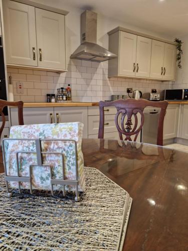 a kitchen with white cabinets and a table and chairs at The Forum-Mountmellick - Coachhouse in Mountmellick