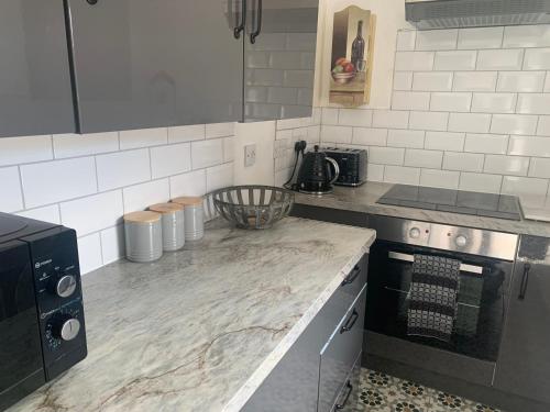 a kitchen with a marble counter top and a stove at Sleeps 7 Home Blackpool w Free Parking BBq WiFi in Blackpool