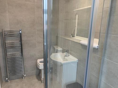 a bathroom with a toilet and a sink and a shower at Sleeps 7 Home Blackpool w Free Parking BBq WiFi in Blackpool