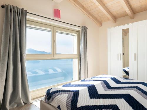 a bedroom with a bed and a large window at Cherubino 2 - Nice 2 floors apartment with pool, terrace and a terrific lake view in Parzanica