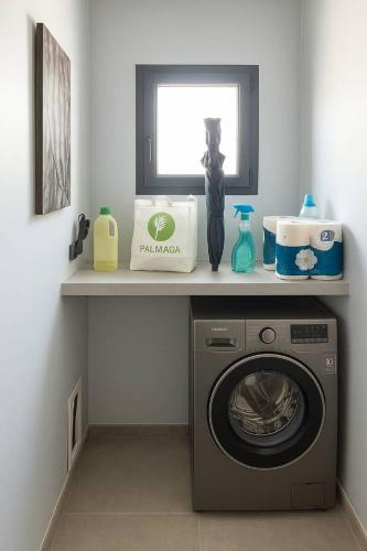 a laundry room with a washing machine on a shelf at Villa Mona in Somone