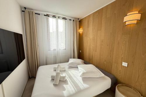 a bedroom with a white bed with towels on it at Superb 6-person T3 apartment close to the slopes in Valberg