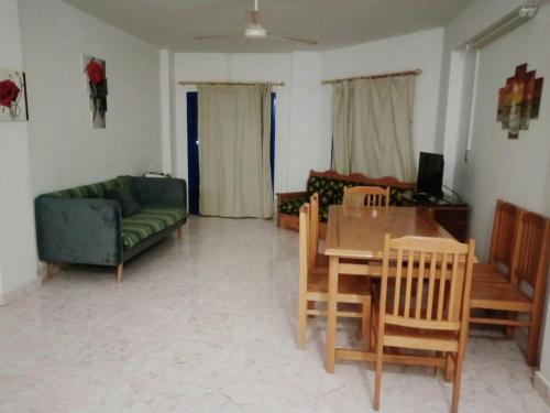 a living room with a couch and a table and chairs at Golden Beach 1 for family in Ras Sedr