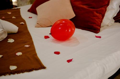 a red tomato sitting on top of a bed at L'Autel La Crypte Mystérieuse de Rouen - sauna & balnéo in Rouen