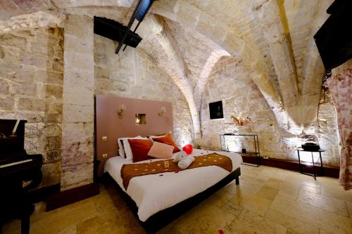 a bedroom with a bed in a stone wall at L'Autel La Crypte Mystérieuse de Rouen - sauna & balnéo in Rouen