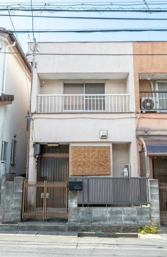 an apartment building with a gate and a balcony at GUEST HOUSE Hotori in Otsu