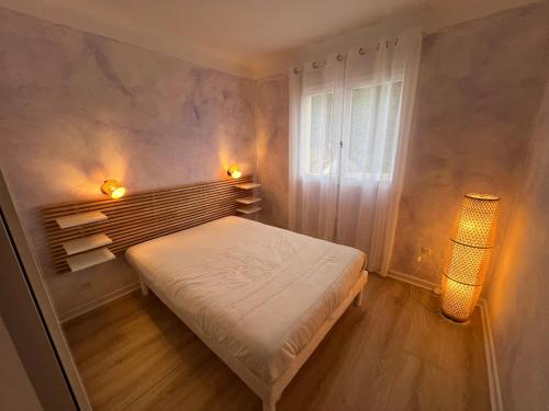 - une petite chambre avec un lit et deux lumières dans l'établissement Villa La Benoite à Carqueiranne, à Carqueiranne