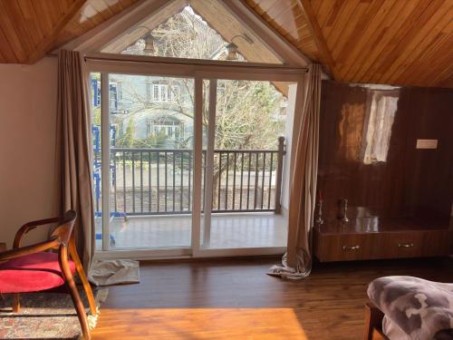 a room with a large sliding glass door at Tropical Green in Srinagar