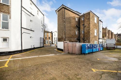 伦敦The Chapter Hotels - Finsbury Park的一个空的停车场,有两个高高的砖楼