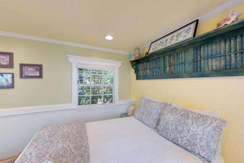 a bedroom with a bed and a window at Charmayne's Cottages - Truman @ Duval in Key West
