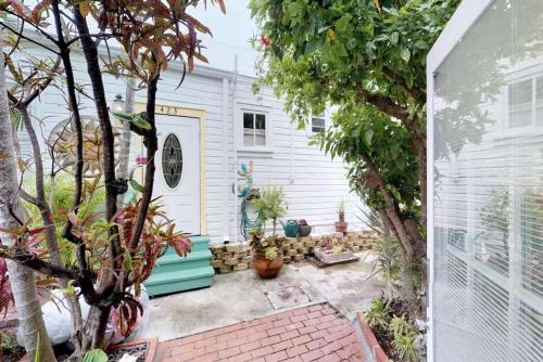 a backyard with a white house with a door at Charmayne's Cottages - Truman @ Duval in Key West